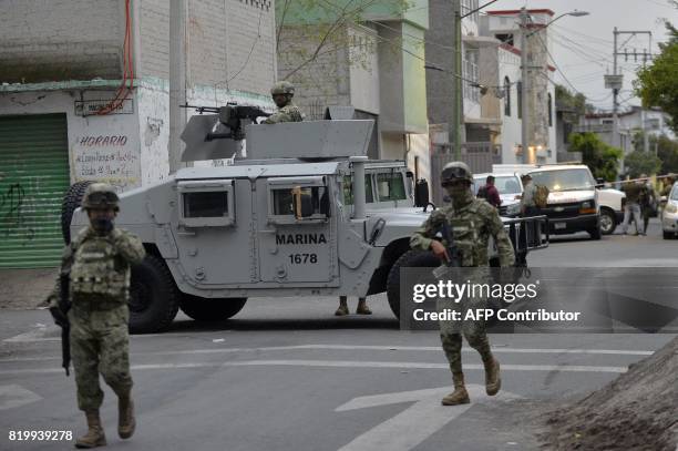 Mexican Navy members stand guard following a shoot-out in which eight alleged drug traffickers were shot dead in Tlahuac, Mexico City, on July 20,...