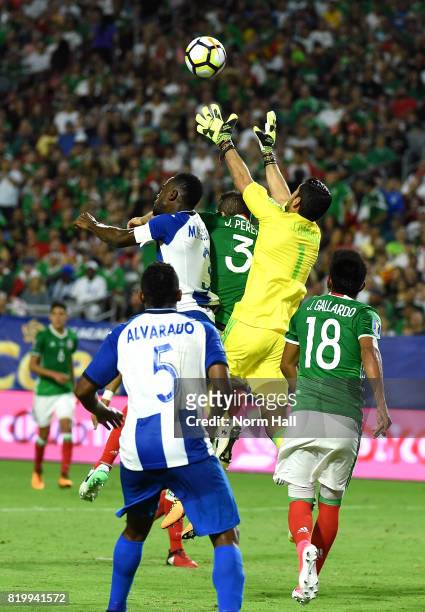 Goalkeeper Jesus Corona of Mexico goes up to make a save as teammate Jair Pereira challenges Maynor Figueroa of Honduras for the ball during the...