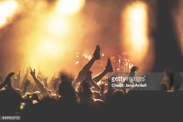 crowd surfer crowd surfing at concert venue - rock music stock-fotos und bilder