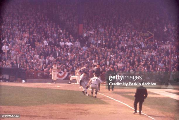 Third baseman Clete Boyer, pitcher Bill Stafford and catcher Johnny Blanchard of the New York Yankees charge the bunted ball during Game 7 of the...