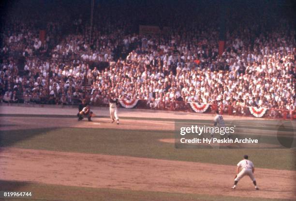 Hal Smith of the Pittsburgh Pirates swings as pitcher Jim Coates and Bobby Richardson of the New York Yankees play defense during Game 7 of the 1960...