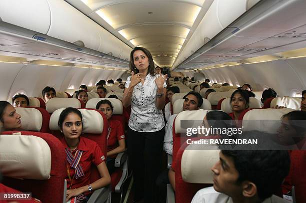 An Air Hostess Academy instructor lectures trainee students on board a Kingfisher Airlines flight from New Delhi to Jaipur on July 19, 2008. A boom...