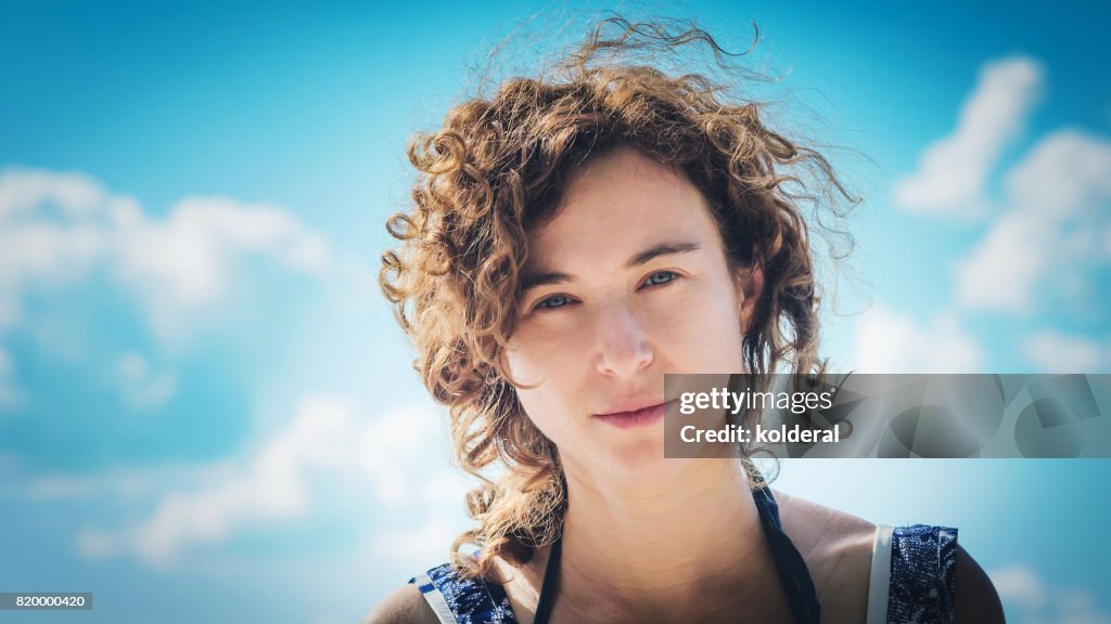 Woman looking at camera with blue sky on background