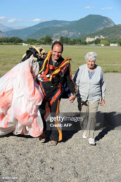 Alice Delfine and her skydiver instructor walk after performing a 2500 m freefall parachute jump on July 19, 2008 at Gap-Tallard aerodrome, southern...