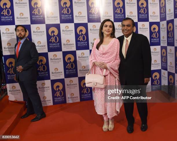 India's richest man and oil-to-telecom conglomerate Reliance Industries chairman Mukesh Ambani and his wife Nita Ambani pose as their son Anant...