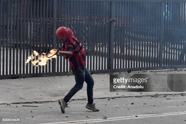Demonstrator throws a molotov cocktail to the Bolivarian National Guards during clashes in an anti-government protest in Caracas, on July 20, 2017. A...