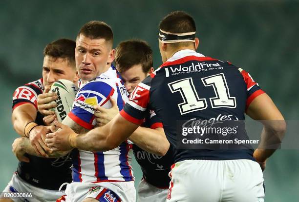 Shaun Kenny-Dowall of the Knights is challenged by his opponets during the round 20 NRL match between the Sydney Roosters and the Newcastle Knights...