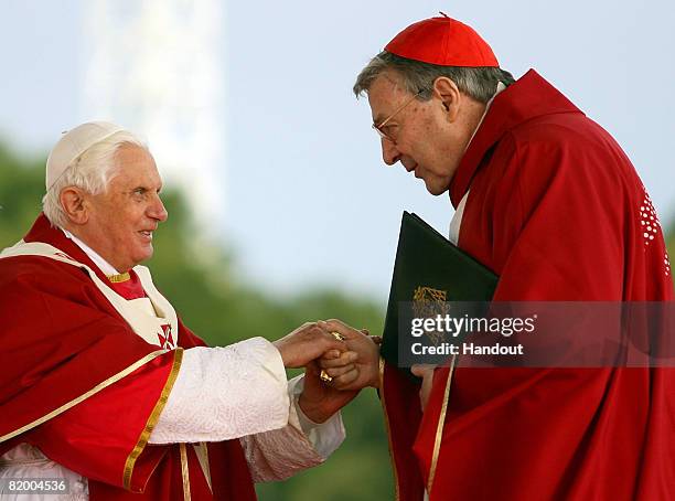 In this handout photo provided by World Youth Day, His Holiness Pope Benedict XVI shakes hands with His Eminence Cardinal George Pell, Catholic...