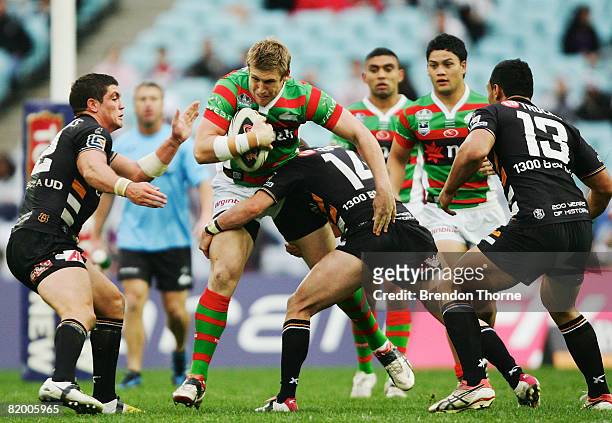 Michael Greenfield of the Rabbitohs is tackled by the Tigers defence during the round 19 NRL match between the South Sydney Rabbitohs and the Wests...