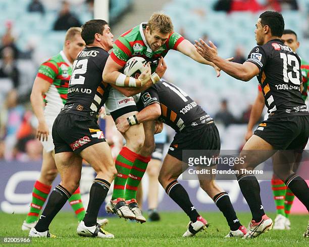 Michael Greenfield of the Rabbitohs is tackled by the Tigers defence during the round 19 NRL match between the South Sydney Rabbitohs and the Wests...