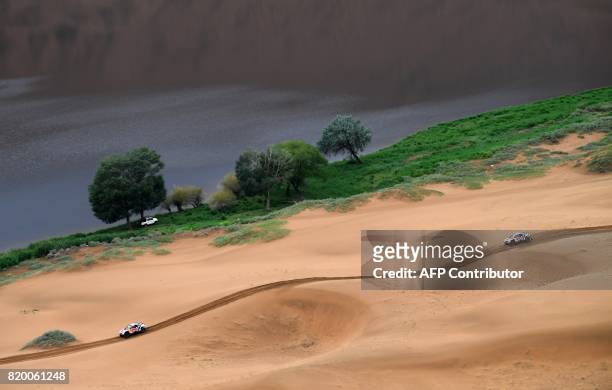 Peugeot's French driver Cyril Despres and co-driver David Castera of France and Peugeot's driver Stephane Peterhansel and his co-driver Jean Paul...