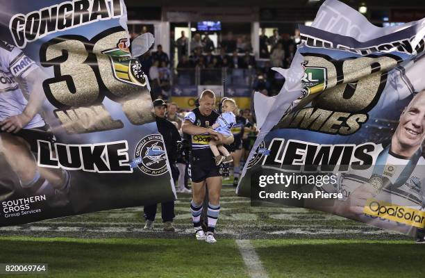 Luke Lewis of the Sharks breaks through the banner as he runs on to play his 300th game during the round 20 NRL match between the Cronulla Sharks and...