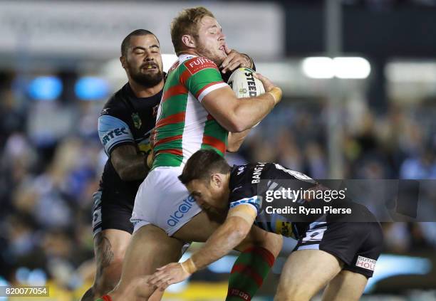 Tom Burgess of the Rabbitohs is tackled by Andrew Fifita of the Sharks during the round 20 NRL match between the Cronulla Sharks and the South Sydney...