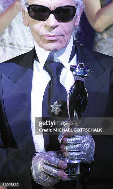 German fashion designer Karl Lagerfeld holds his Mercedes Platinum trophy he was given during the Elle Fashion Star 2008 award at the Berlin Fashion...