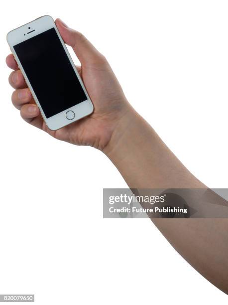 Detail of a hand holding an Apple iPhone SE smartphone, taken on April 7, 2016.