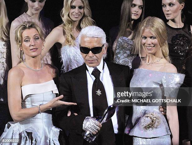 German fashion designer Karl Lagerfeld is flanked by German top model Claudia Schiffer and German actress Maria Furtwaengler after being given the...