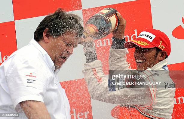 McLaren Mercedes' British driver Lewis Hamilton celebrates with Mercedes-Benz motorsport's president Norbert Haug on the podium of the Hockenheim...