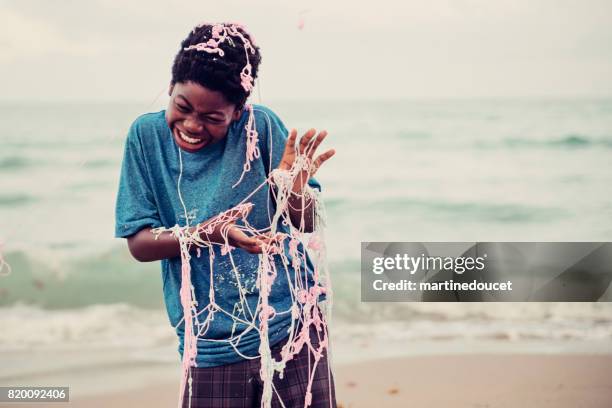 young african american boy being string sprayed on the beach. - silly string stock pictures, royalty-free photos & images