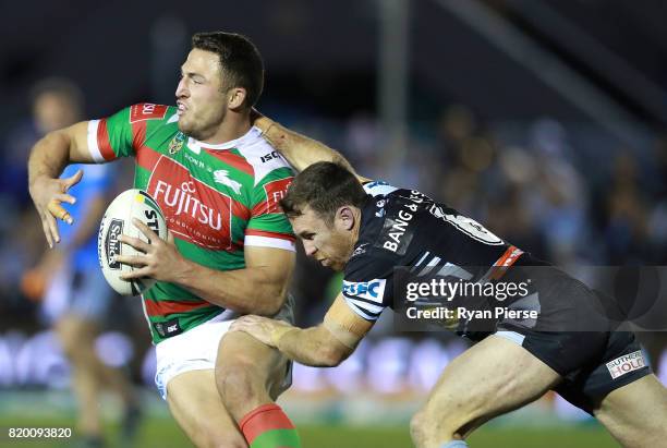 Sam Burgess of the Rabbitohs is tackled by James Maloney of the Sharks during the round 20 NRL match between the Cronulla Sharks and the South Sydney...