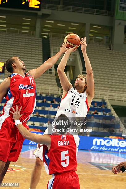 Dirk Nowitzki of Germany shoots against Ricardo Sanchez of Puerto Rico compete during the Fiba Olympic Qualifier match between Germany and Puerto...