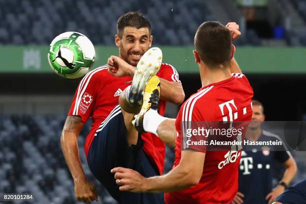 Javier Martinez of FC Bayern Muenchen battles for the ball with his team mate Rafinha during a training session at Shenzhen Universiade Sports Centre...