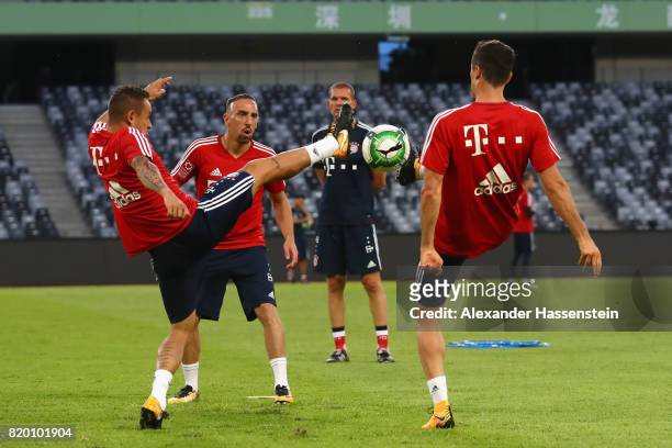 Rafinha of FC Bayern Muenchen battle for the ball with his team mates Franck Ribery and Robert Lewandowski during a training session at Shenzhen...