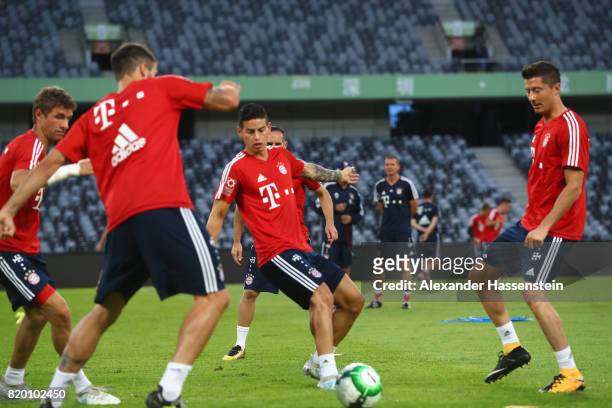 Thomas Mueller of FC Bayern Muenchen battle for the ball with his team mates Javier Martinez, James Rodriquez and Robert Lewandowski during a...