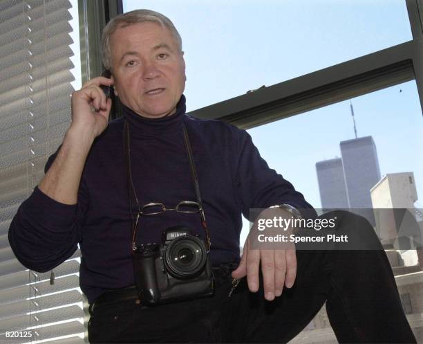 World famous celebrity photographer Arnaldo Magnani makes calls on his cell phone March 19, 2001 as the World Trade Center's Twin Towers rise in the...
