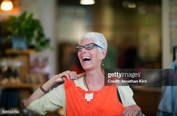 senior woman shops. - orange dress fotografías e imágenes de stock