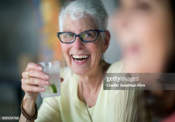 senior woman has a drink. - gin and tonic stock pictures, royalty-free photos & images