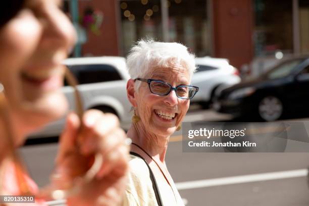 senior women walk down a sunny street. - famille avec des lunettes de vue photos et images de collection