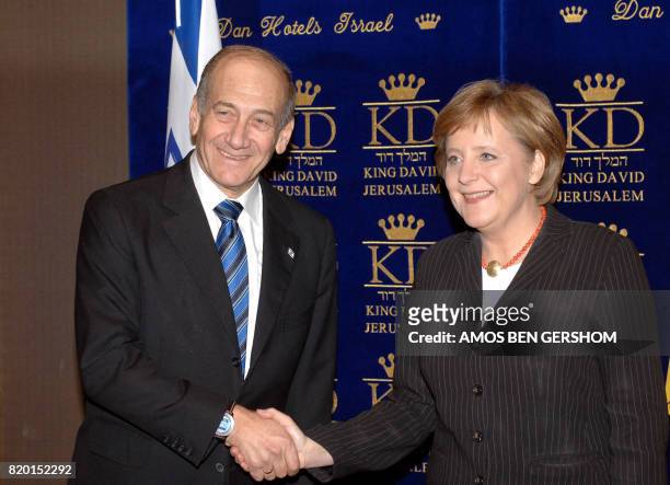 German Chancellor Angela Merkel, , speaks with acting Israeli Prime Minister Ehud Olmert prior to a dinner late 29 January 2006, in Jeruslaem. Olmert...