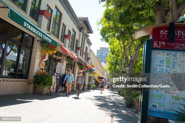 Two people walk down a trendy section of Center Street, near UC Berkeley in downtown Berkeley, California, July 14, 2017.