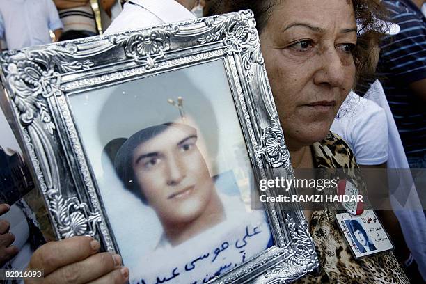 Lebanese woman carries the picture of her son believed to be held in Syria's jails during a rally in Hazmieh on the road leading to Baabda's...