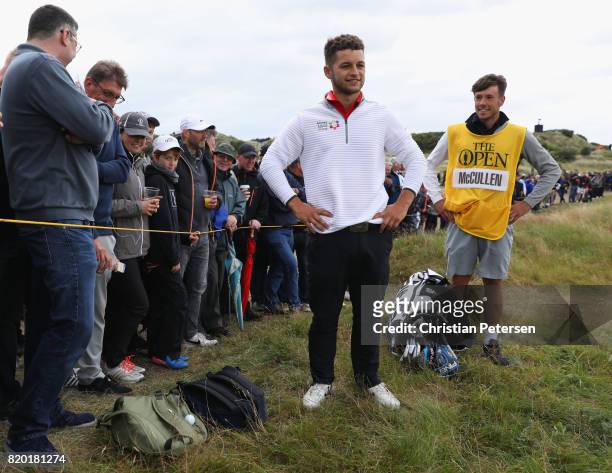 Haydn McCullen of England waits for a rules official as his ball lands on the bag of a spectator during the second round of the 146th Open...