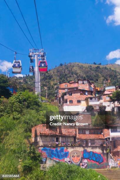 metro cable cars over medellin colombia connecting mountain life to city. - metro medellin stock pictures, royalty-free photos & images