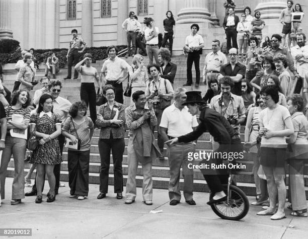 French performance artist Philippe Petit rides a unicycle for an appreciative audience on the stops of the Metropolitan Museum of Art, New York, New...