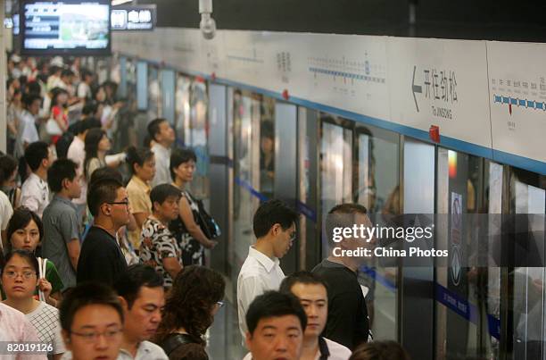 Passengers wait to board a train at the Zhichunlu Station on the Subway Line 10 July 21, 2008 in Beijing, China. Line 10 reached its passenger peak...