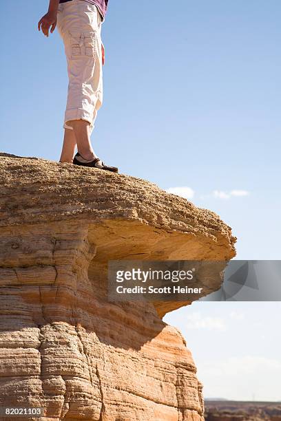 young woman looks over a ledge. - looking over cliff stock pictures, royalty-free photos & images