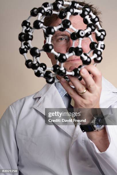 buckyball or fullerene molecular mode with scientist - buckyball stock pictures, royalty-free photos & images