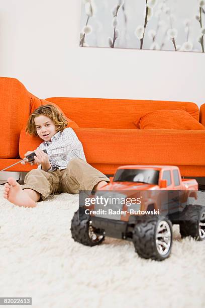 boy (6-7) playing with remote control car - remote controlled car stockfoto's en -beelden