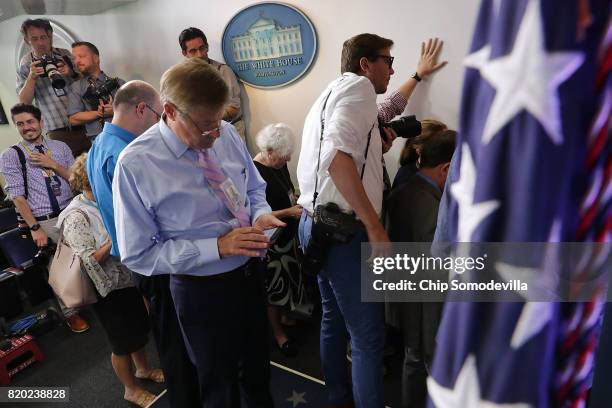 Journalists crowd the entrance to the White House press office after it was learned that Press Secretary Sean Spicer has resigned July 21, 2017 in...