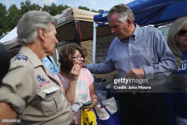 Virginia Governor Terry McAuliffe speaks with dental patient Virginia Mconnell while visiting the Remote Area Medical , mobile clinic on July 21,...