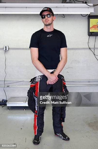 Ben Kennedy, driver of the Weber Chevrolet, stands in the garage area during practice for the NASCAR XFINITY Series Lilly Diabetes 250 at...