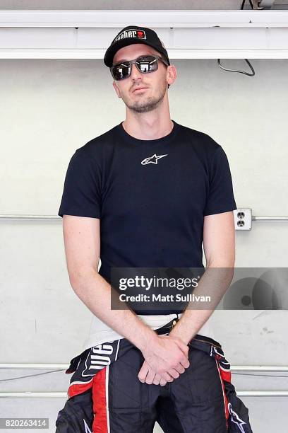 Ben Kennedy, driver of the Weber Chevrolet, stands in the garage area during practice for the NASCAR XFINITY Series Lilly Diabetes 250 at...