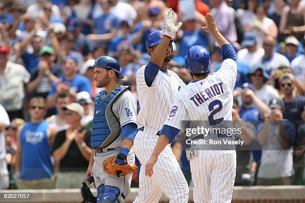 Derrek Lee of the Chicago Cubs greets teammate Ryan Theriot after hitting a home run during the game against the Los Angeles Dodgers at Wrigley Field...