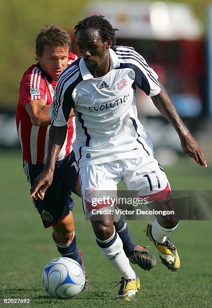 Kheli Dube of the New England Revolution dribbles the ball on the attack as Jesse Marsch of CD Chivas USA gives chase in the first half during their...