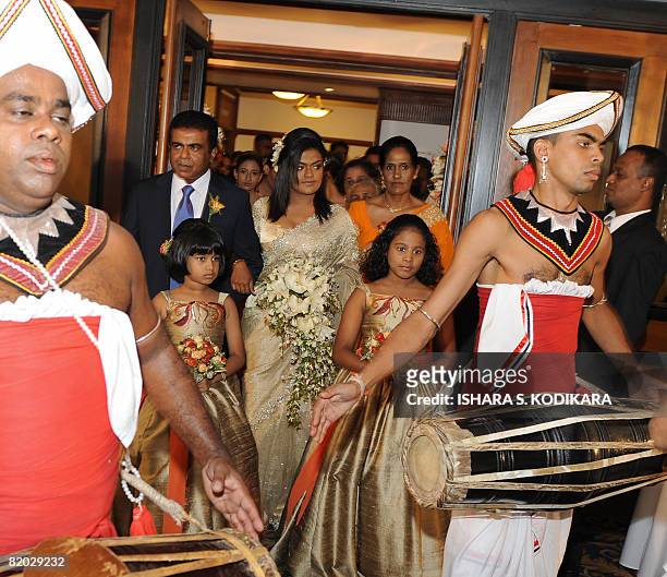Lifestyle-SriLanka-weddings" by Mel Gunasekera A pair of Sri Lankan traditional kandyan dancers walk ahead of a bride at a lavish wedding party in...