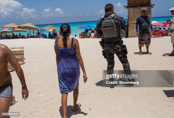 Federal Police officer patrols a beach in Cancun, Mexico, on Wednesday, July 11, 2017. The narco-traffickers already hold sway over swaths of Mexico,...