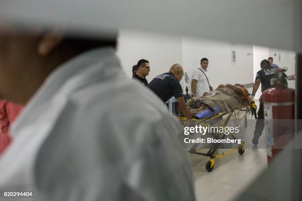 Paramedics unload a patient injured in a shooting at the General Hospital in Cancun, Mexico, on Tuesday, July 11, 2017. The narco-traffickers already...